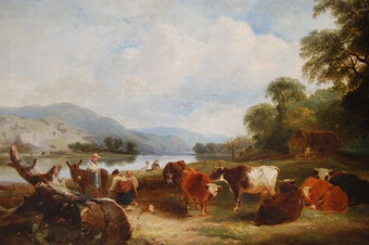 A river landscape with herders and their cattle resting by  the river bank
