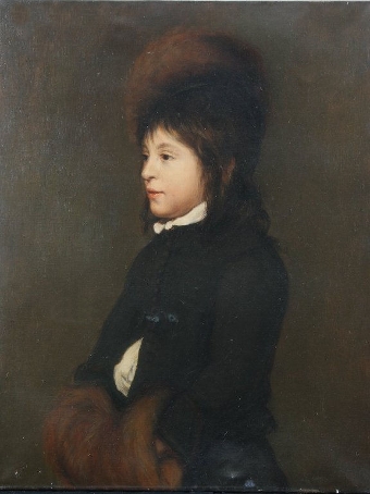 Portrait of a young boy aged 11 in a black coat, fur hat and muff
