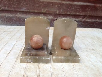 Art-deco greyish coloured marble book ends with salmon pink coloured orbs