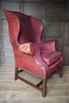 A vintage worn leather wing chair
