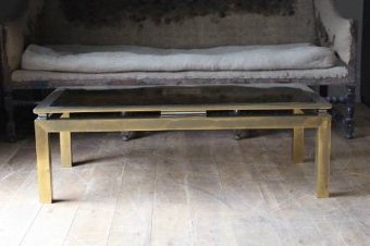 A large brass coffee table in the style of Guy Lefevre