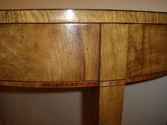 Antique A PAIR OF FINE REGENCY DESIGN DEMI-LUNE CONSOLE TABLES VENEERED IN FINELY CRAFTED YEW,SATINWOOD,MAHOGANY AND BURR-WALNUT HAVING EBONY STRINGING & CHERRYWOOD INLAY & STANDING ON TAPERED LEGS 