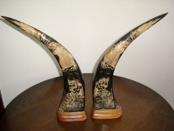 PAIR OF CHINESE BUFFALO HORNS HAND DECORATED WITH A DRAGON & TIGERS ABOVE CARVED WOODEN BASE PLYN...