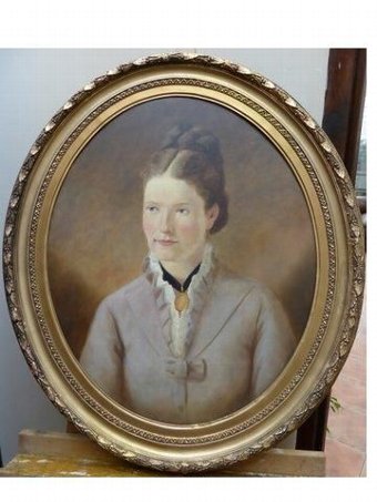 LATE 19TH CENTURY OIL PORTRAIT OF YOUNG LADY WEARING GOLD BROACH PRESENTED IN DECORATIVE OVAL GIL...
