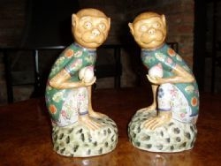 PAIR OF PORCELAIN ENAMELLED MONKEYS SITTING HOLDING FRUIT 