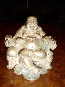 FAUX SILVER BUDDHA SITTING WITH BROAD SMILE