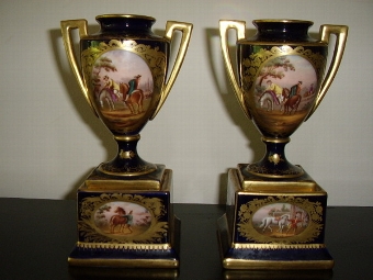 Antique A PAIR OF MINATURE HAND PAINTED CONTINENTAL VASES WITH GILT HANDLES