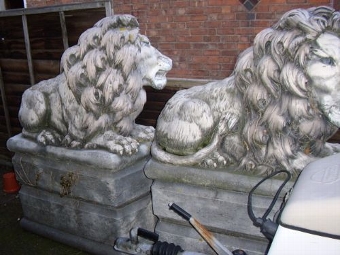PAIR OF STONE LIONS ON RAISED PLINTHS