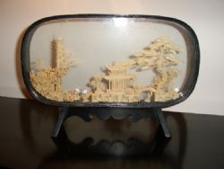 HAND CRAFTED CORK CARVING DEPICTING ORIENTAL HOUSE WITH TREES & BIRDS IN GLASS CASE ON STAND
