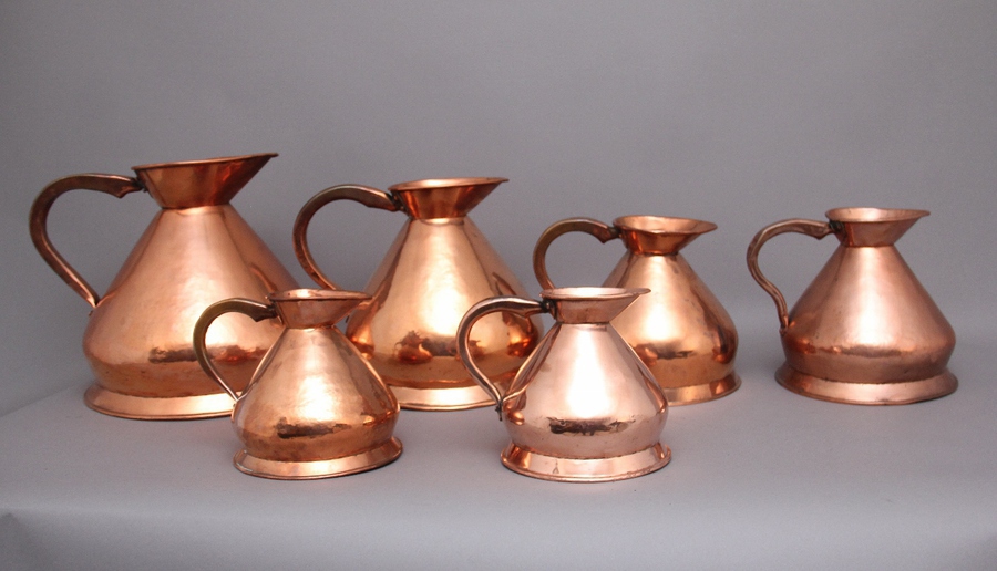 Antique A set of six highly decorative 19th Century copper measuring jugs