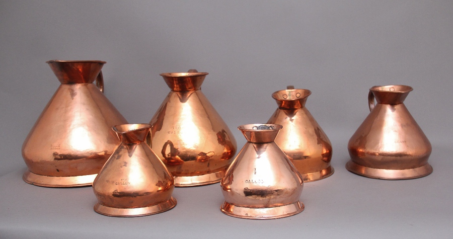 Antique A set of six highly decorative 19th Century copper measuring jugs