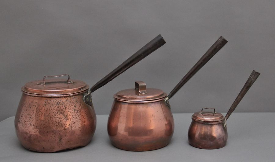Antique A set of three Victorian copper saucepans