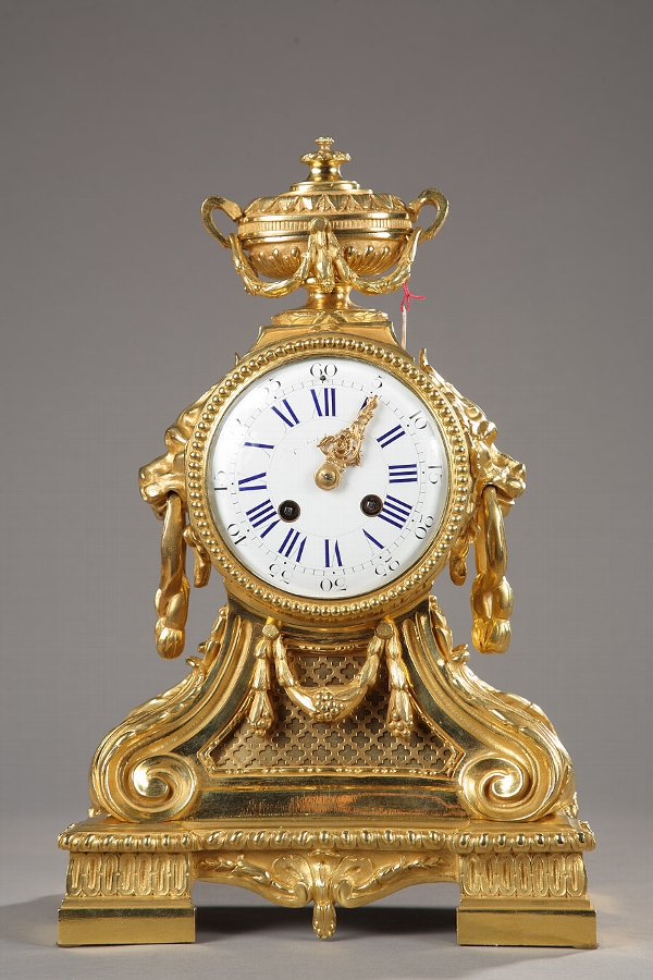 A French 19th century gilded bronze mantel clock with lion heads