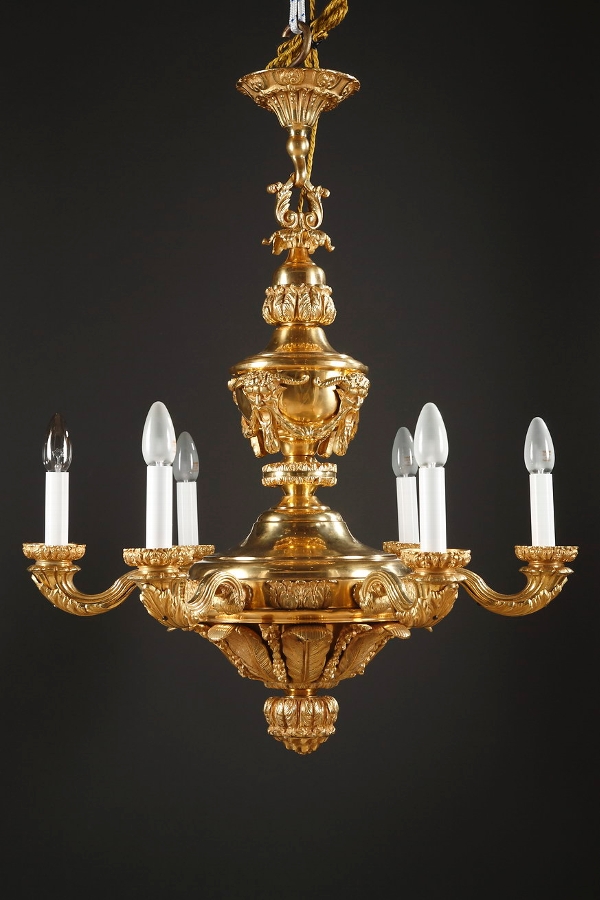 A French ormolu six-lights chandelier decorated with masks and cornucopias