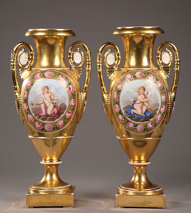 A pair of gilt 19th century porcelain vases with polychrome gallant scenes and Cupids