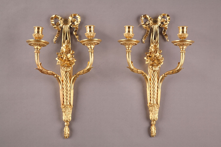 A pair of Louis XVI style two lights sconces in gilt bronze