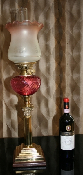 CRANBERRY OIL LAMP ON BRASS AND WOODEN COLOUMN.