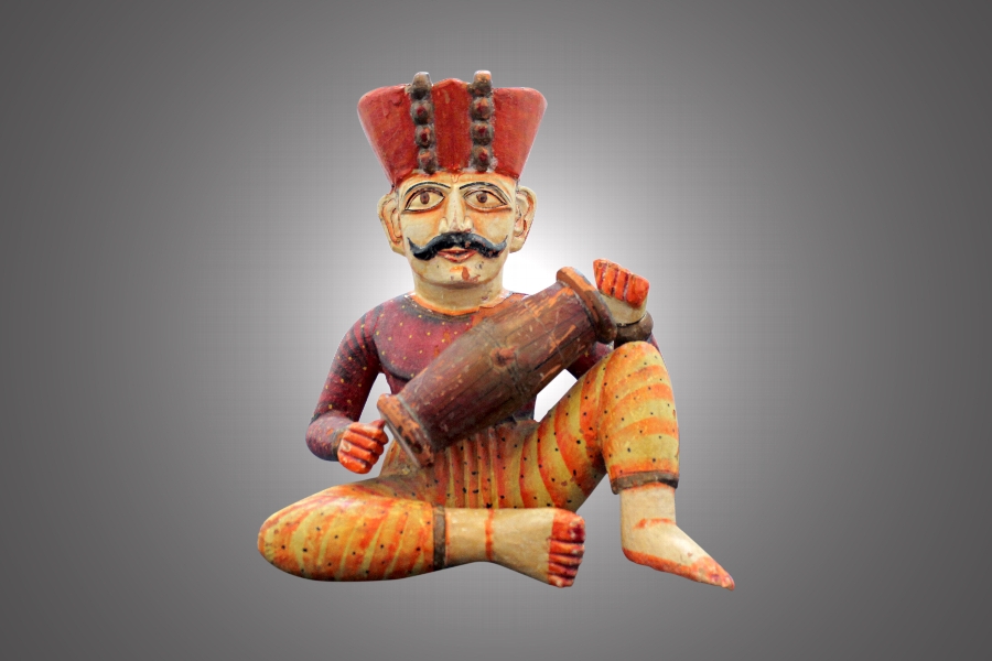 AN INDIAN CARVED WOOD POLYCHROME FIGURE OF A MUSICIAN 