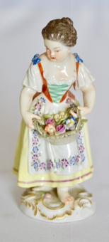 Antique A pair of Meissen figurines of a boy and girl carrying baskets of flowers, early