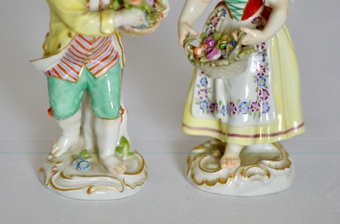 Antique A pair of Meissen figurines of a boy and girl carrying baskets of flowers, early