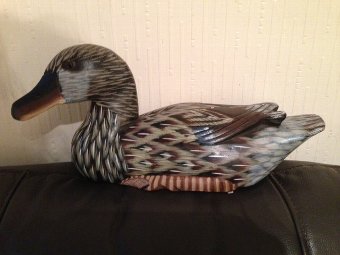 A 20th century carved 33cm by 10cm wooden painted decoy duck with brown glass eyes.