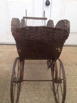 Antique Rare and fine example of a late 19th early 20th century child’s painted wooden dolls pram with a rush-work trim on 4 iron wheels.