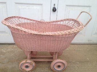 An attractive mid-20th century pink painted wickerwork dolls pram.