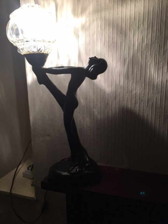 Antique A very stylish mid-20th century French moulded high gloss black resin statue table-lamp of a woman holding a blobbed moulded clear glass globe. 