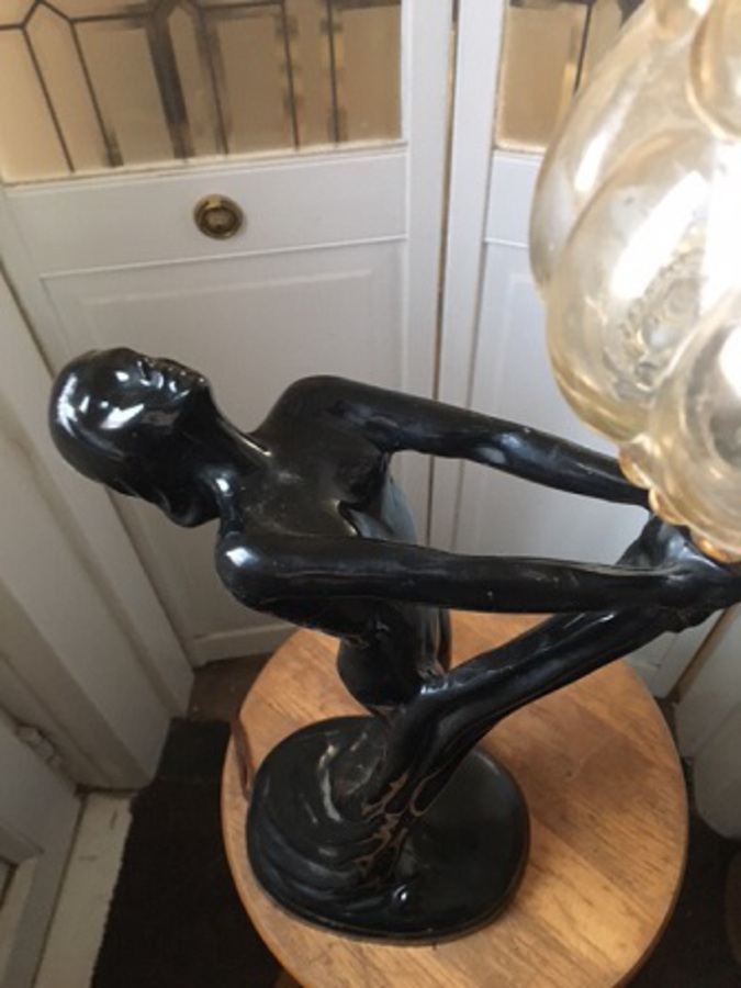 Antique A very stylish mid-20th century French moulded high gloss black resin statue table-lamp of a woman holding a blobbed moulded clear glass globe. 