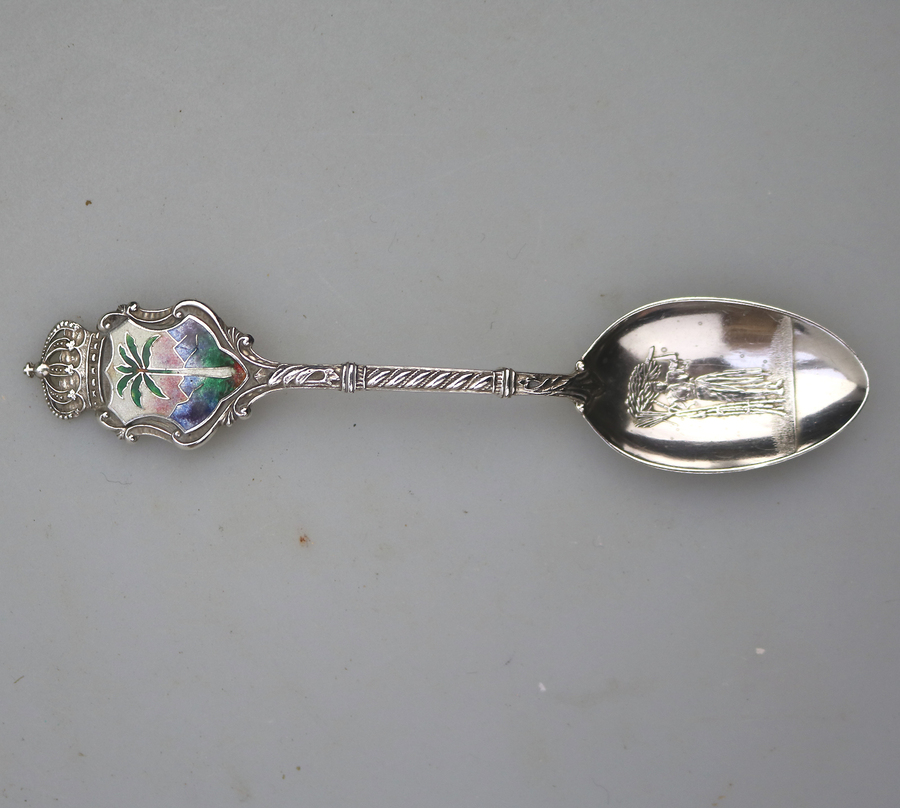 An antique sterling solid silver souvenir spoon with enamelled palm tree C.20thC
