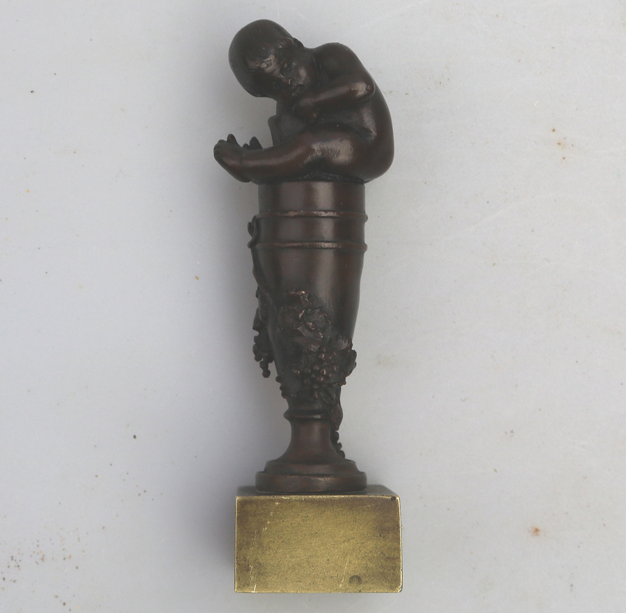 A good antique novelty bronze figural Desk Seal child sat on wine ewer C.19thC