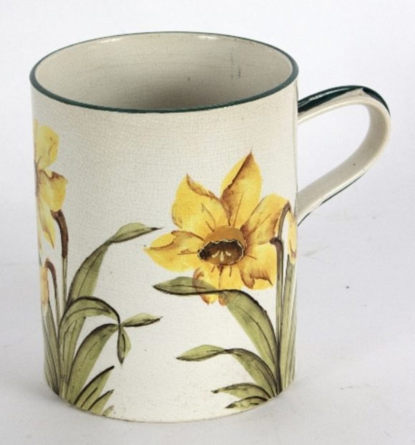 A Wemyss mug painted daffodils within green borders