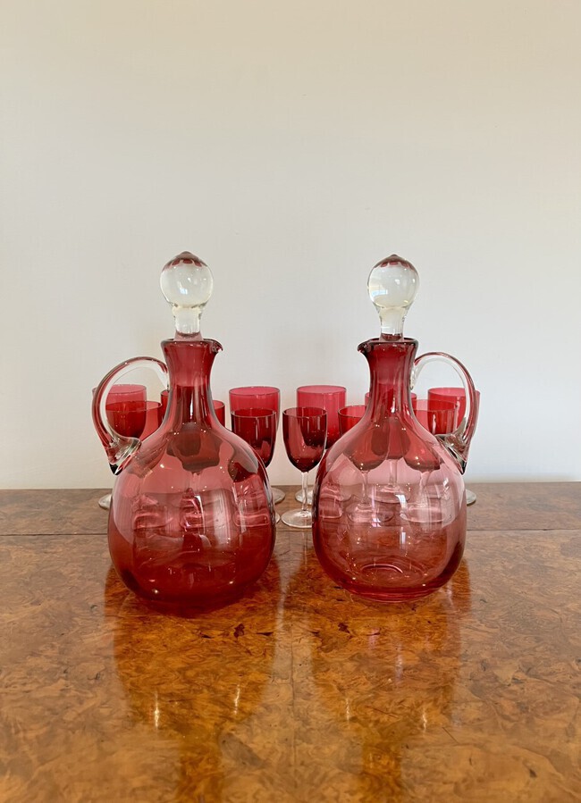 Pair of quality Antique Victorian Cranberry Glass Decanters with twelve cranberry glass wine glas...