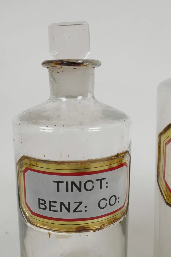 Antique Three antique chemist bottles and stoppers with enamelled labels	