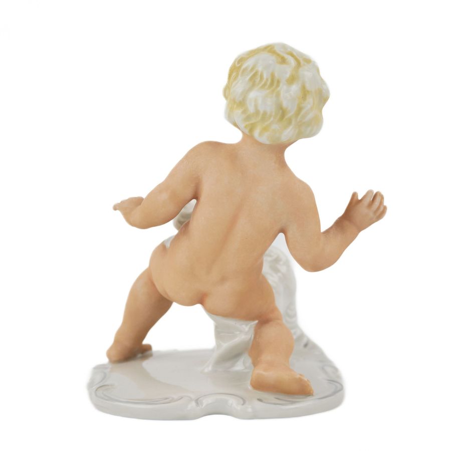 Antique Porcelain figurine of Putti playing with a dog. Germany.