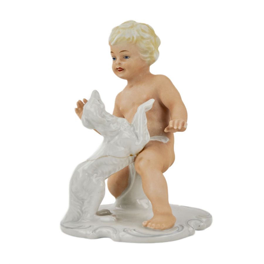Antique Porcelain figurine of Putti playing with a dog. Germany.