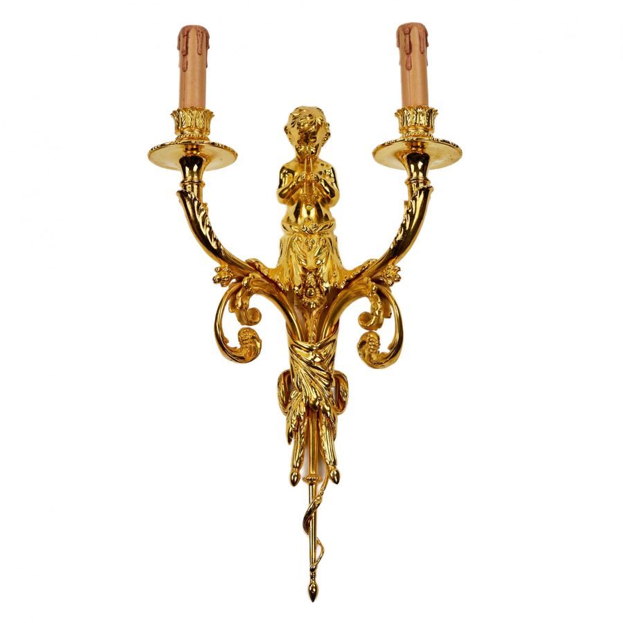 Antique A pair of gilded sconces, with currency curls, surmounted by cherubs.