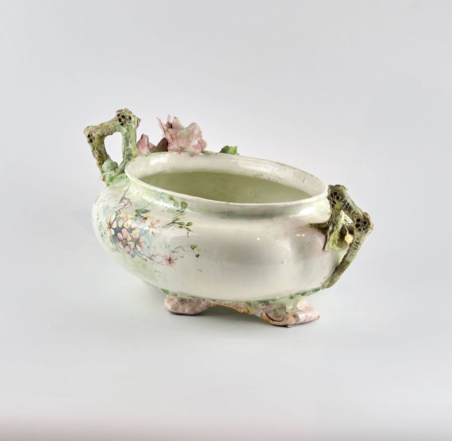 Antique Liberty style faience pot with sprouting flowers.