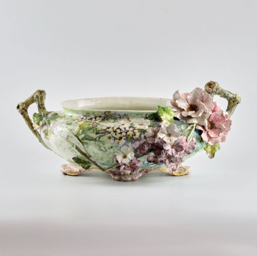 Antique Liberty style faience pot with sprouting flowers.