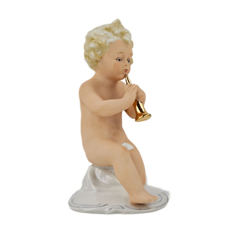 Antique A figurine of a putti playing music on a pipe.