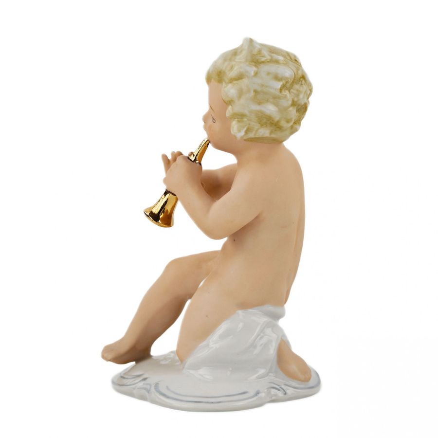 Antique A figurine of a putti playing music on a pipe.