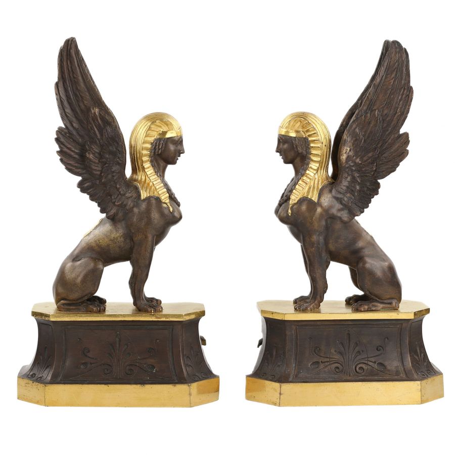 A pair of patinated and gilded bronze firewood stands in the shape of winged sphinxes. 19th centu...