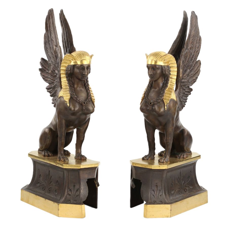 Antique A pair of patinated and gilded bronze firewood stands in the shape of winged sphinxes. 19th century.