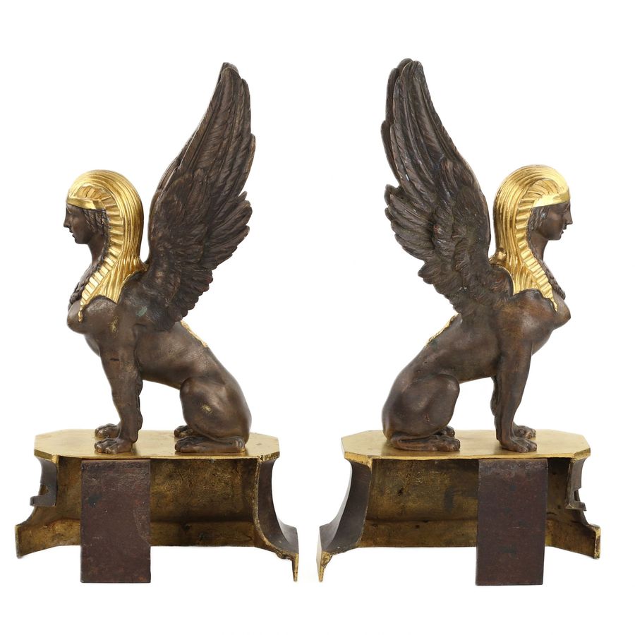 Antique A pair of patinated and gilded bronze firewood stands in the shape of winged sphinxes. 19th century.