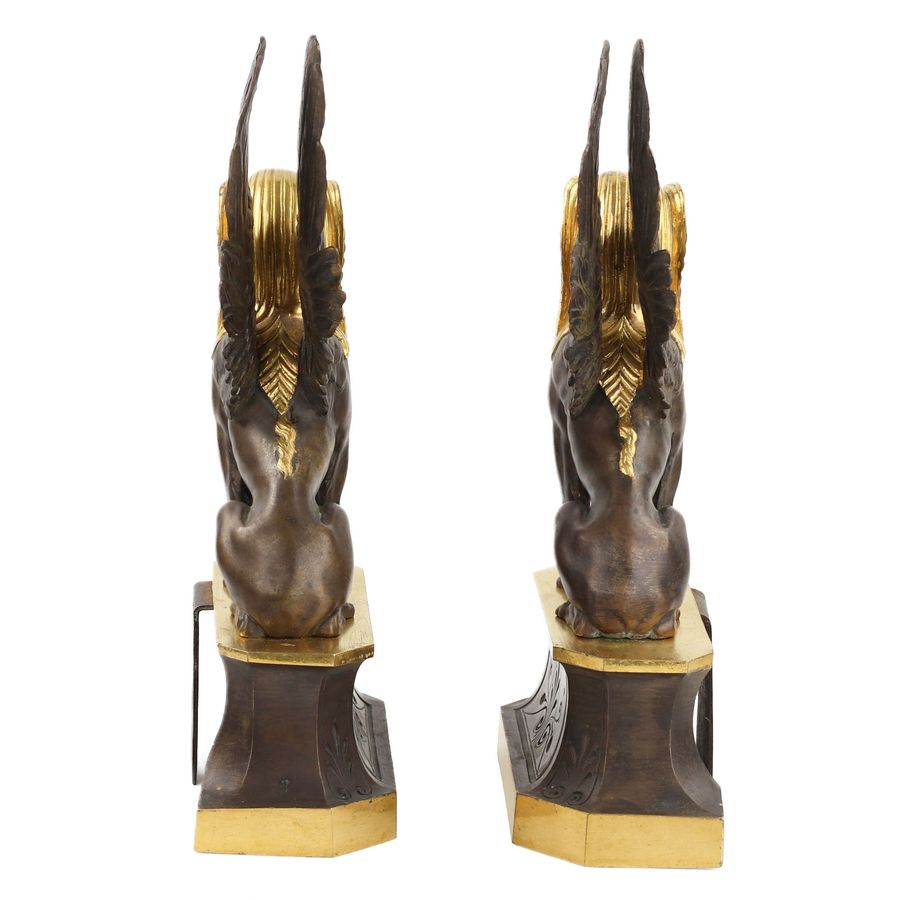 Antique A pair of patinated and gilded bronze firewood stands in the shape of winged sphinxes. 19th century.