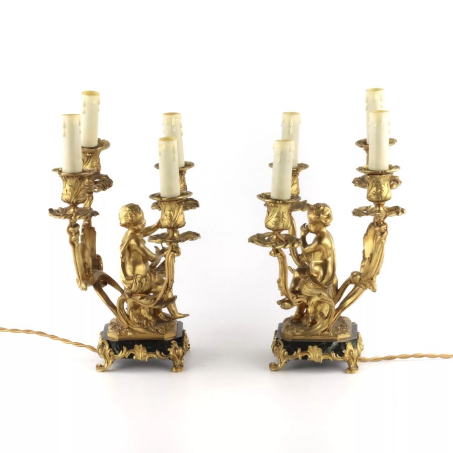 Antique Paired lamps of gilded bronze with cupids playing music.