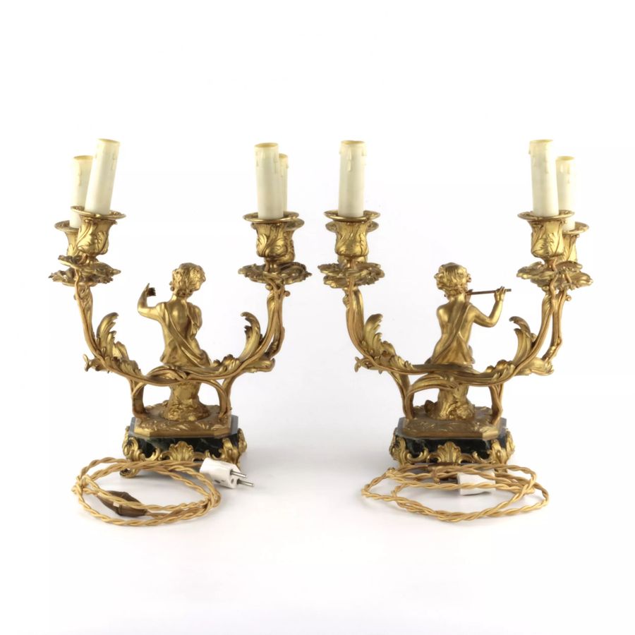 Antique Paired lamps of gilded bronze with cupids playing music.