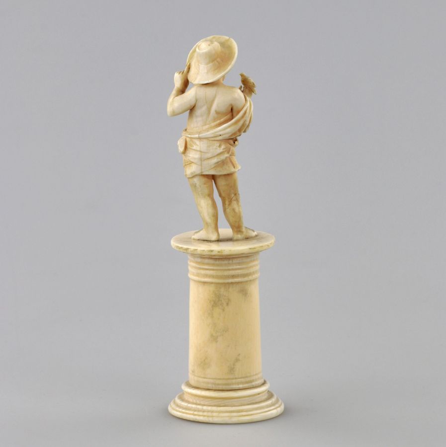 Antique Carved ivory figurine of a boy with a bird 1800s.