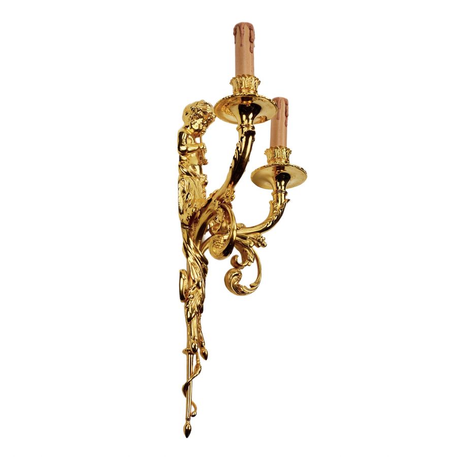 Antique A pair of gilded sconces, with currency curls, surmounted by cherubs.