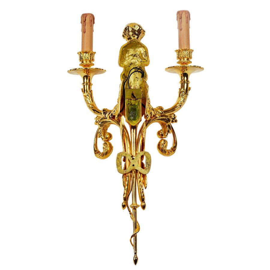 Antique A pair of gilded sconces, with currency curls, surmounted by cherubs.